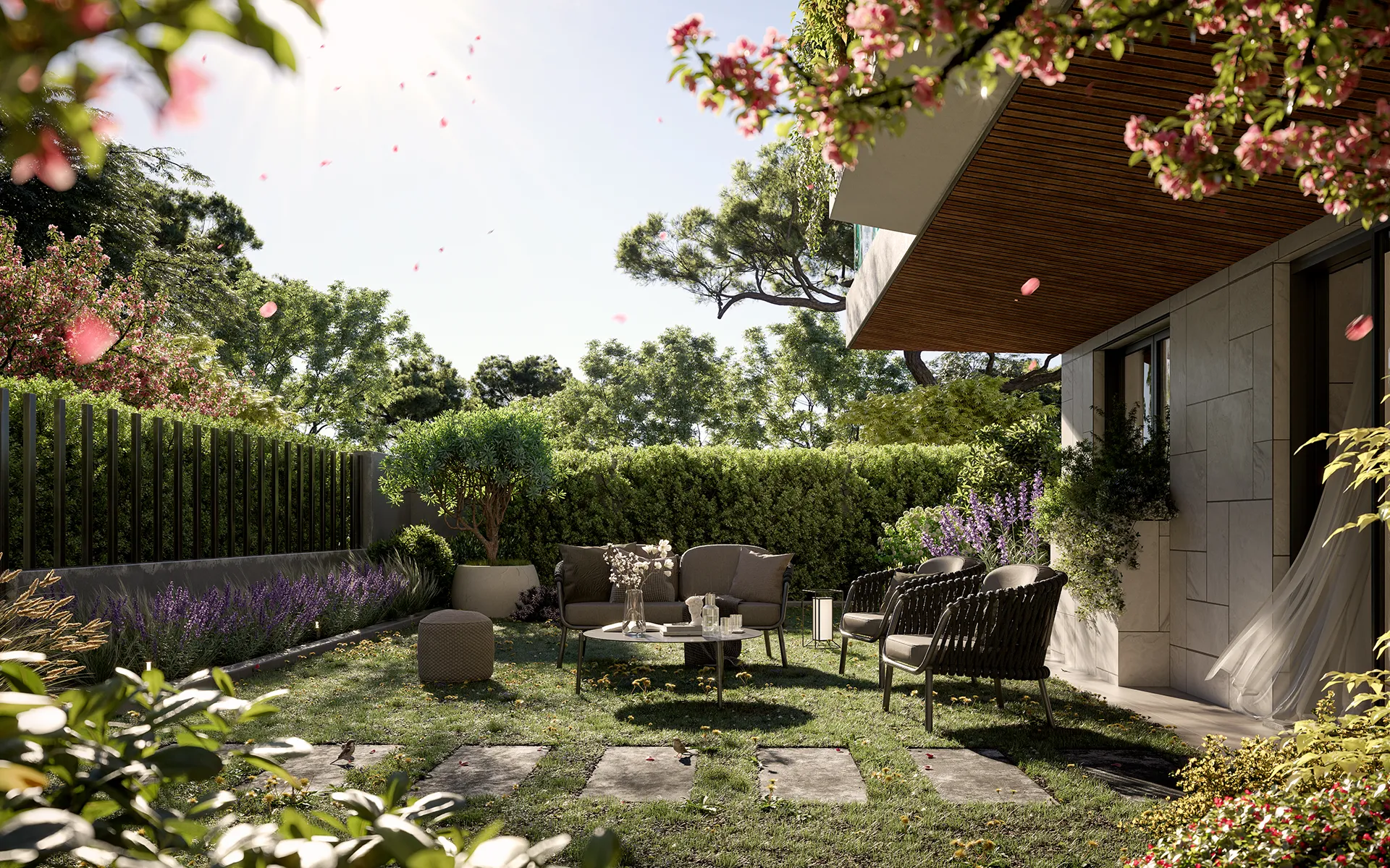 Modern outdoor patio seating area with chairs, table, greenery, flowers, and stone path on lawn.